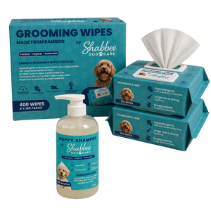 Shabbee Dog Care grooming bundle including a bottle of puppy shampoo and four packs of grooming wipes, all in teal packaging with white tissue and clear liquid.