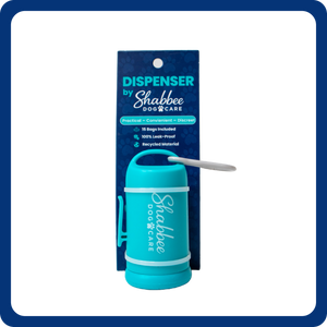 A Shabbee Dog Care dispenser in bright teal, shown with its dark blue retail packaging card. The dispenser has a white logo printed on it and a small gray pull tab.